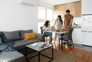 A happy family sitting together in a comfortable living room, enjoying an efficient and well-maintained air conditioner.