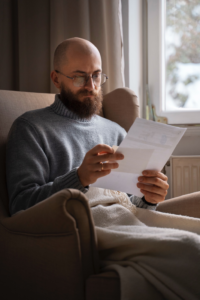 A man reviewing a high electricity bill while frustrated with his A/C system.